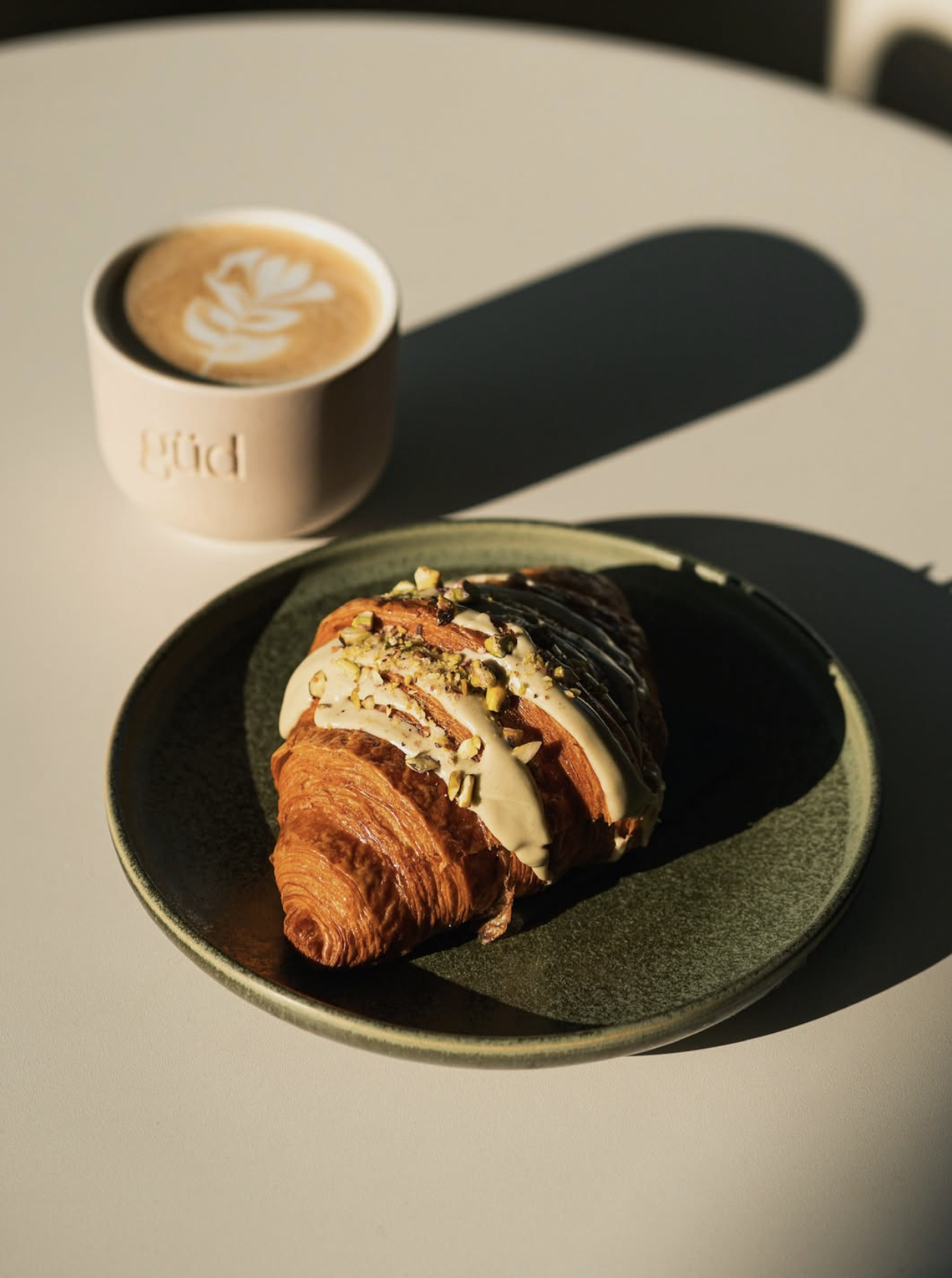 güd specialty hub — pistachio croissant and latte